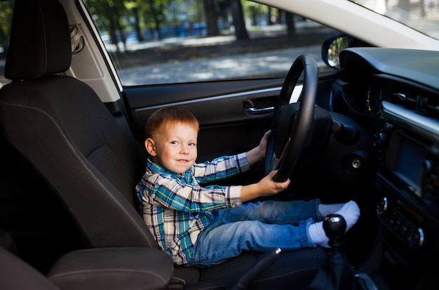 Netter kleiner Junge, der Vaterauto fährt