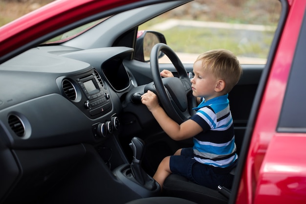 Netter kleiner Junge, der Vaters Auto fährt