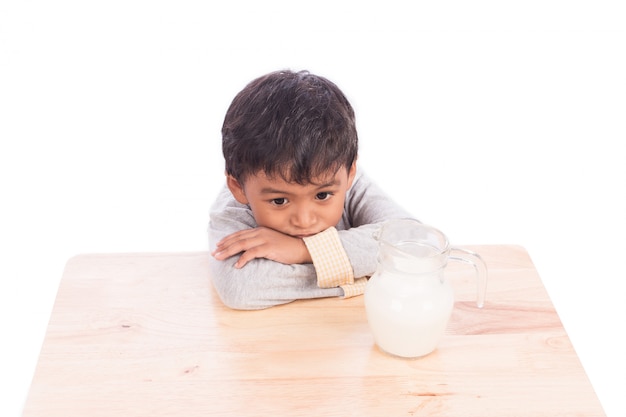 Netter kleiner Junge gelangweilt mit Milch