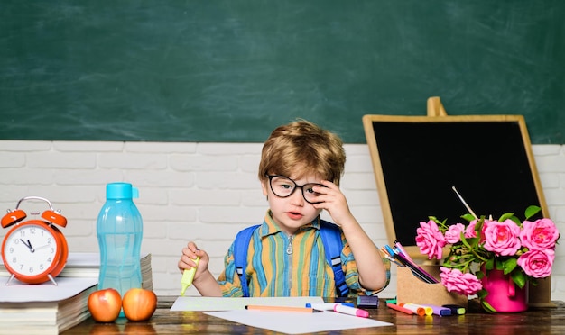 Netter kleiner Junge im Klassenzimmer in der Nähe der Tafel. Kind macht sich bereit für den Tag der Schullehrer