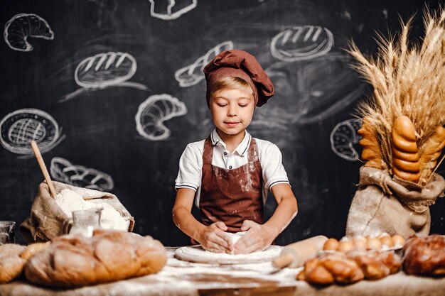 Netter kleiner Junge mit dem Chefhutkochen