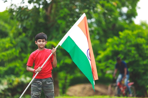 Netter kleiner Junge mit indischer dreifarbiger Nationalflagge