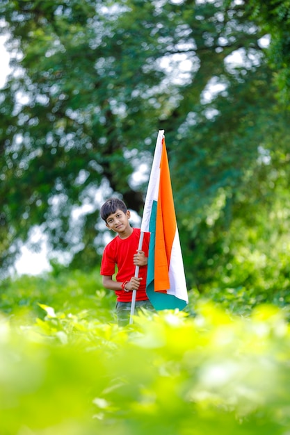 Netter kleiner Junge mit indischer dreifarbiger Nationalflagge