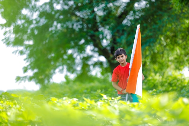 Netter kleiner Junge mit indischer dreifarbiger Nationalflagge