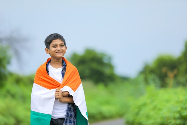 Netter kleiner Junge mit indischer dreifarbiger Nationalflagge