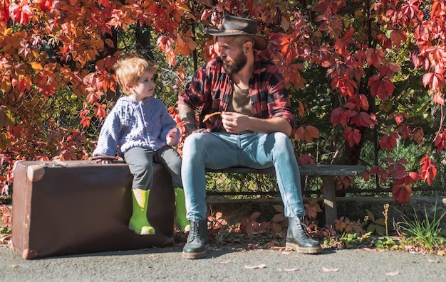 Netter kleiner Junge mit seinem Vater beim Spaziergang im Wald Vater und Sohn im Herbstpark spielen lachen