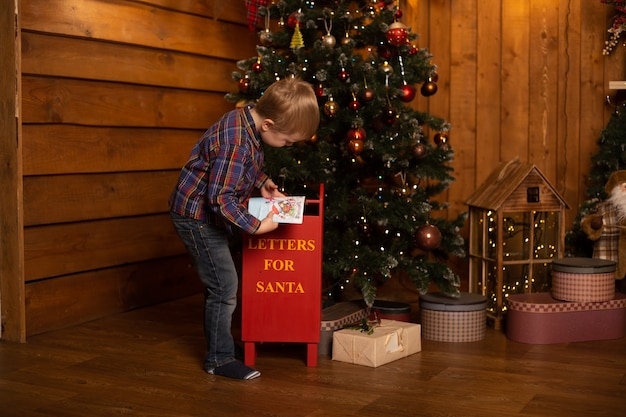 Netter kleiner Junge nahe Weihnachtsbaum