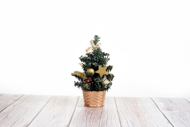 Netter kleiner Weihnachtsbaum auf Holztisch auf weißem Hintergrund