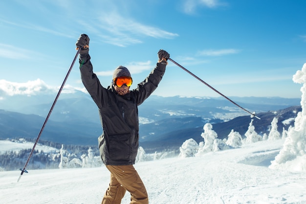 Netter Mann, der in den Bergen Ski fährt.