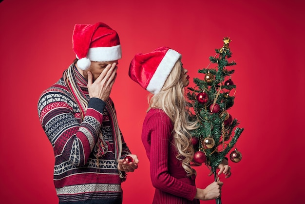 Netter Mann und Frau Neujahr Baum Dekoration Urlaub roten Hintergrund