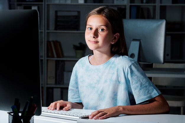 Netter Mittelschüler, der Sie beim Vorbereiten des Seminars am späten Abend im Klassenzimmer ansieht