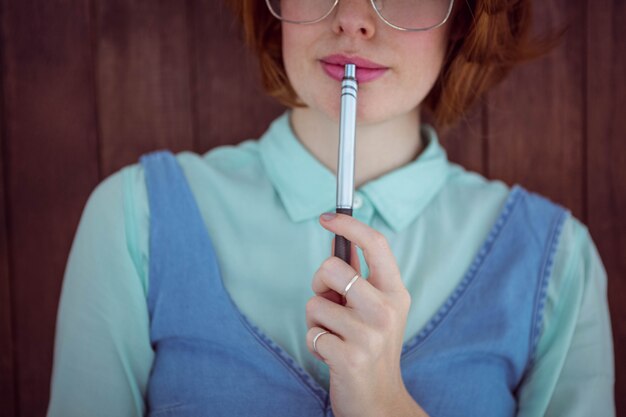 Netter roter behaarter Hippie, der einen Stift kaut