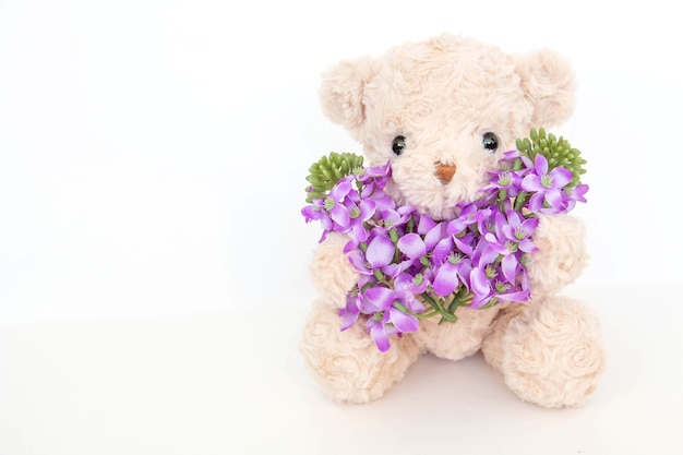 Foto netter teddybär mit pastellblume