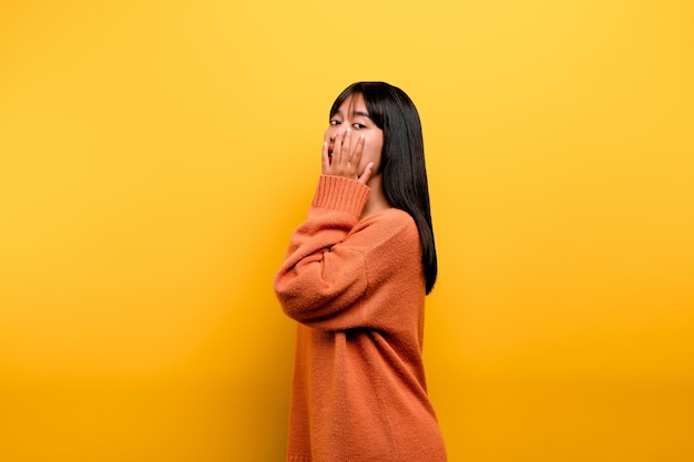 Nettes asiatisches Mädchen, das auf gelbem Hintergrund lächelt Leere junge Frau Platz für Werbekopienraum