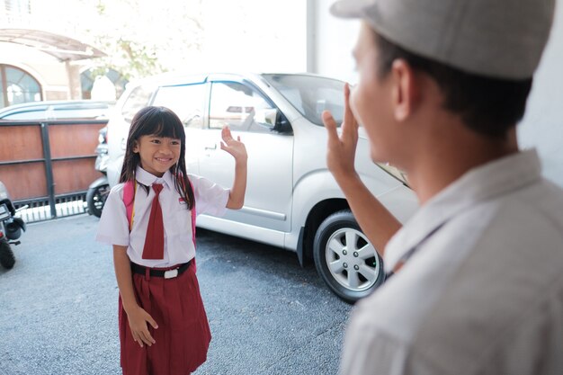 Nettes asiatisches Schülermädchen mit Rucksack, das zur Schule geht