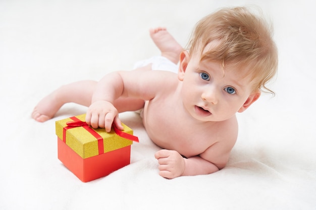 Nettes Baby, das mit einer Geschenkbox spielt