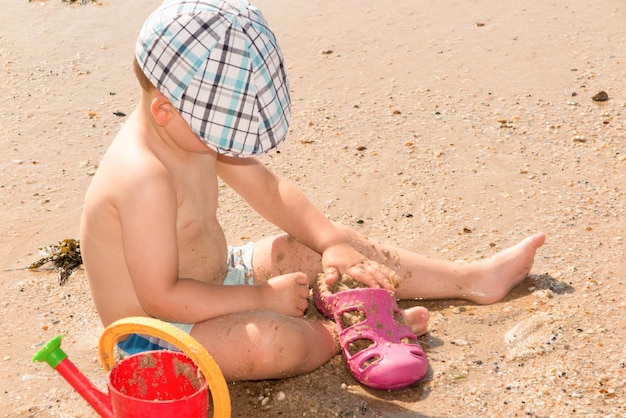 Nettes Baby, das mit Strandspielwaren spielt