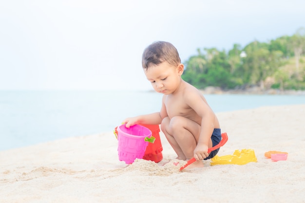 Nettes Baby, das mit Strandspielwaren spielt