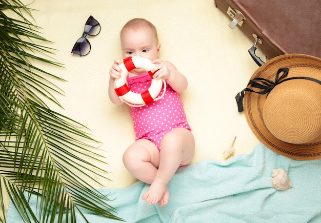 Nettes Baby, das Rettungsring auf hellem Hintergrund hält. Urlaub auf See mit Baby, Sommerkonzept