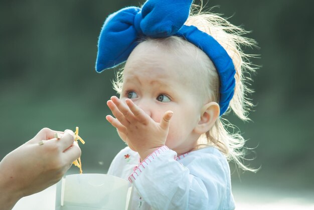 Foto nettes baby-gilr isst thailändisches essen im freien