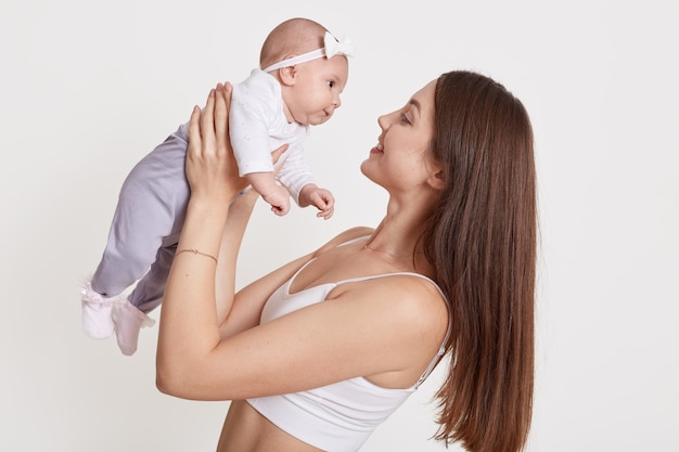 Nettes Baby in den Armen der Mutter lokalisiert über Weiß