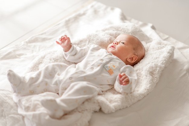 Nettes Baby in einem Schlafzimmer der weißen Leuchte Neugeborenes Baby ist nett.