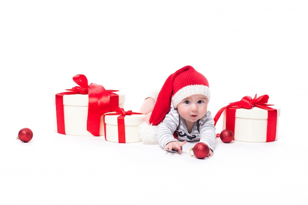 Nettes Baby in einer roten Kappe des neuen Jahres mit einem Lächeln auf seinem Gesicht