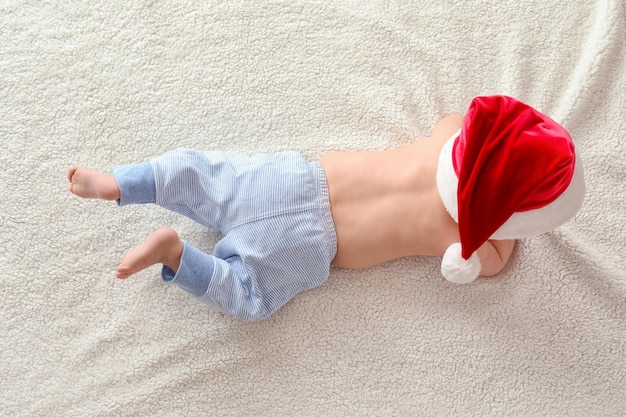 Nettes Baby in Weihnachtsmütze auf hellem Hintergrund