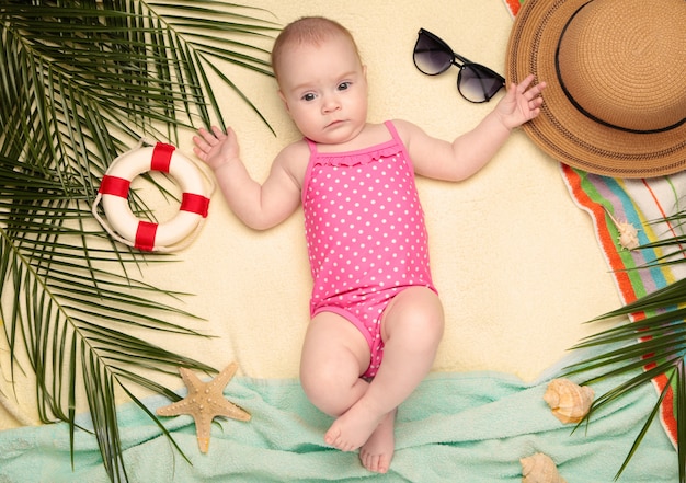 Nettes Baby mit Strandaccessoires. Urlaub auf See mit Baby, Sommerkonzept