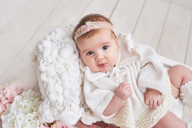 Nettes Babymädchen in gestrickter Kleidung Muttertag Internationaler Tag des Glücks