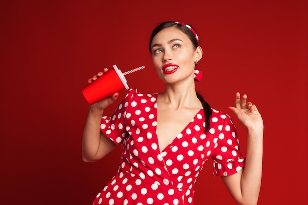 Nettes Brunette Pin-up-Girl, das alkoholfreies Getränk hält