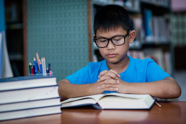 Nettes Buch des kleinen Jungen Lese in der Bibliothek