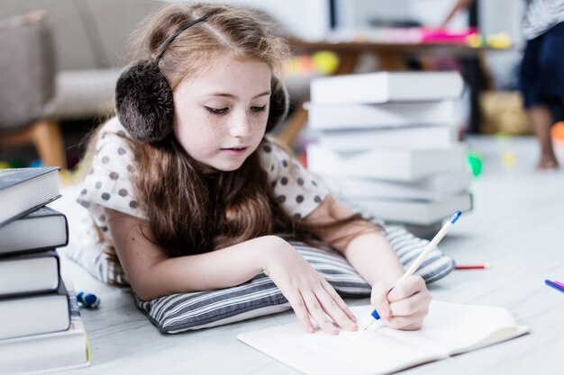 Nettes Glückkindermädchen ist haben Spaß und frohen Moment mit Weißraum backgroun des Studienbuches