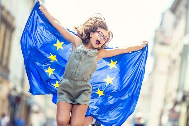 Nettes glückliches junges Mädchen mit der Flagge der Europäischen Union.
