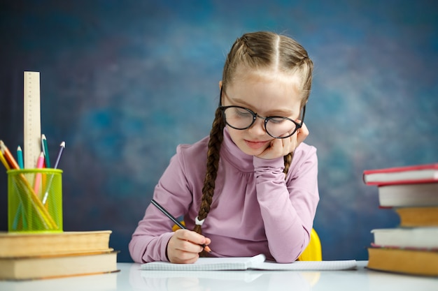 Nettes Grundschulmädchen Hausaufgaben machen Lehrbuch lesen