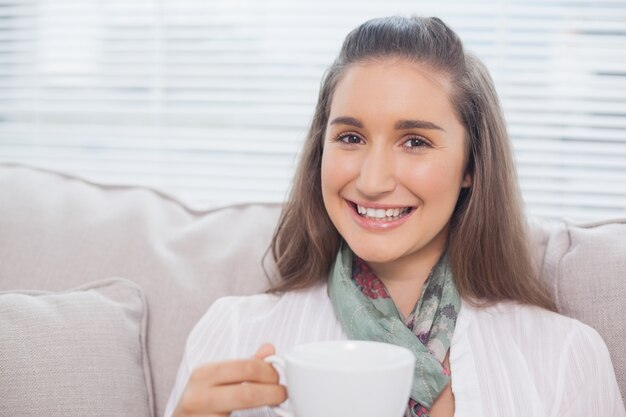 Nettes hübsches Modell, das Kaffee hält