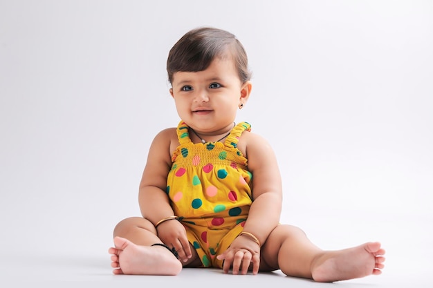 Nettes indisches Babymädchen, das lächelt und Ausdruck gibt
