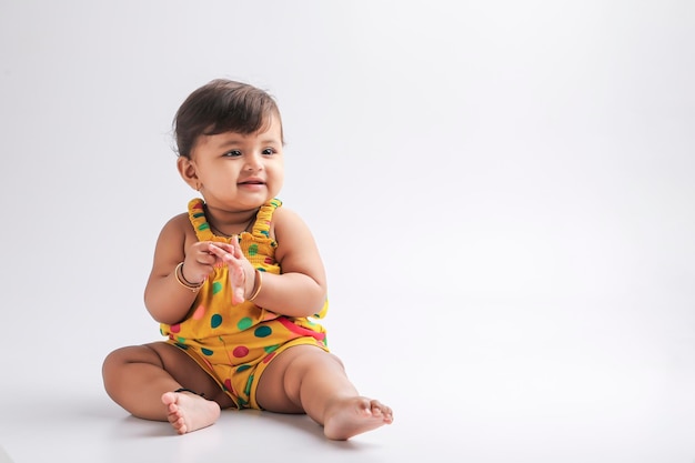 Nettes indisches Babymädchen, das lächelt und Ausdruck gibt