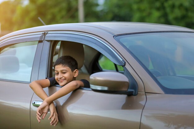 Nettes indisches Kind, das in einem Auto sitzt
