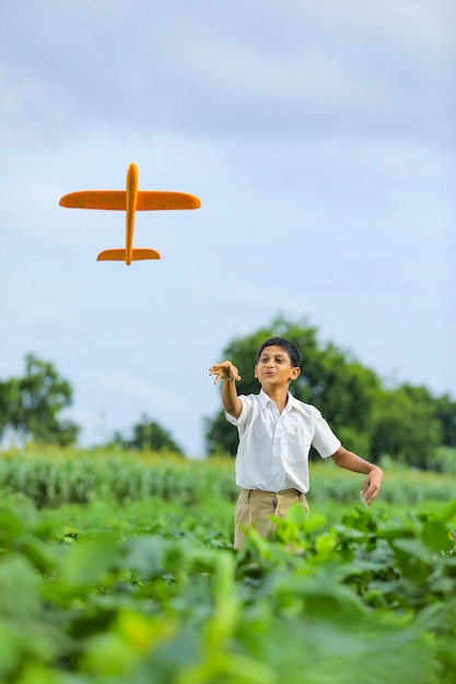 Nettes indisches Kind, das mit einem Spielzeugflugzeug spielt