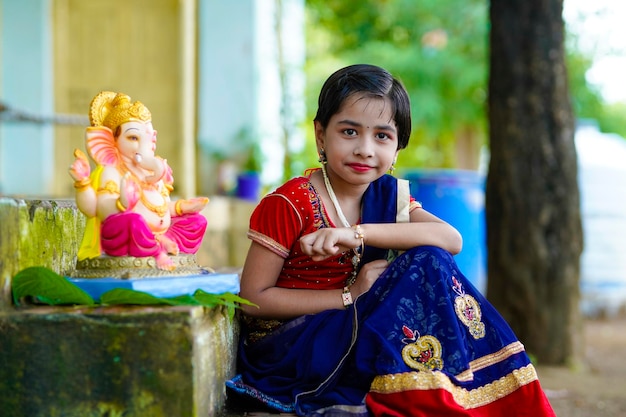 Nettes indisches kleines mädchen, das lord ganesha festival feiert