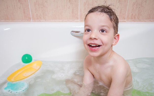 Nettes Jungenglück beim Baden in einer Badewanne bath