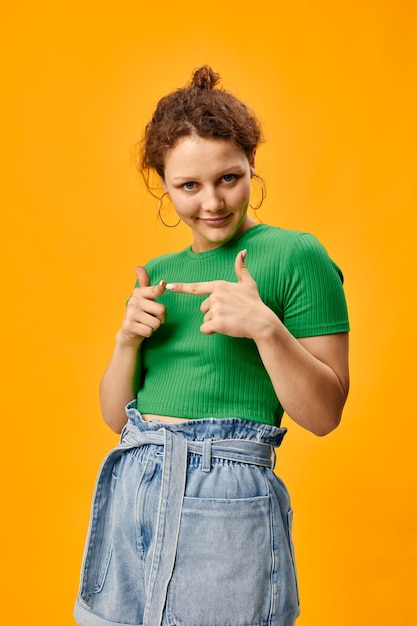 Nettes junges Mädchen in grünen T-Shirt-Denim-Shorts posiert