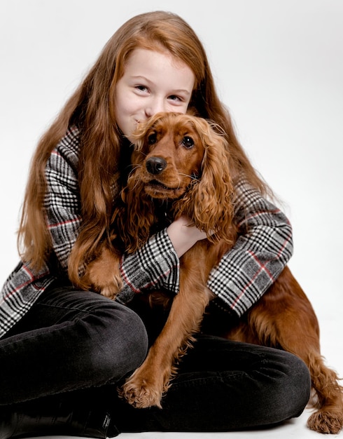 Nettes junges Mädchen umarmt Welpen Cocker Spaniel Hund Teenager Mädchen spielt mit Spaniel isoliert auf weiß