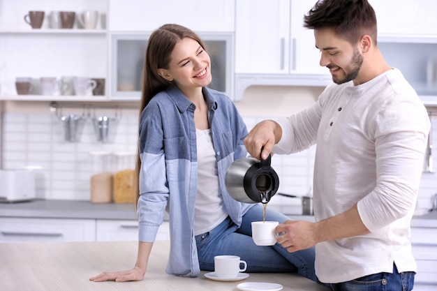 Nettes junges Paar, das Kaffee in der Küche trinkt