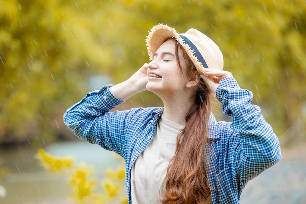 Nettes junges reizendes brünettes jugendlich Mädchen glücklich lächelnde Regenzeit im Freien