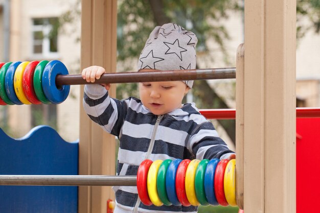 Nettes Kind auf dem Spielplatz Kind, das im Freien auf dem Spielplatz spielt