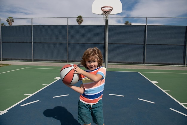 Nettes Kind, das Basketball spielt Kind, das Basketball mit Basketball spielt Basketballkinderschule