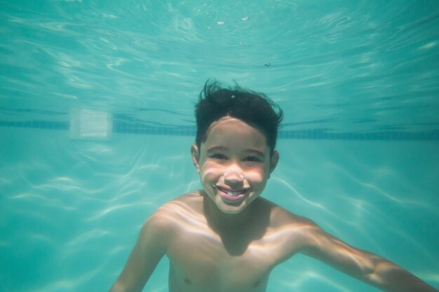 Nettes Kind, das unter Wasser im Pool aufwirft