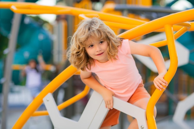 Nettes kind der kindheit, das spaß auf dem spielplatz hat glückliches kind, das spaß auf dem spielplatz hat kind, das auf playg klettert